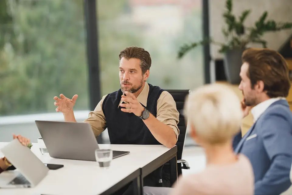 A small team discussing work around a laptop