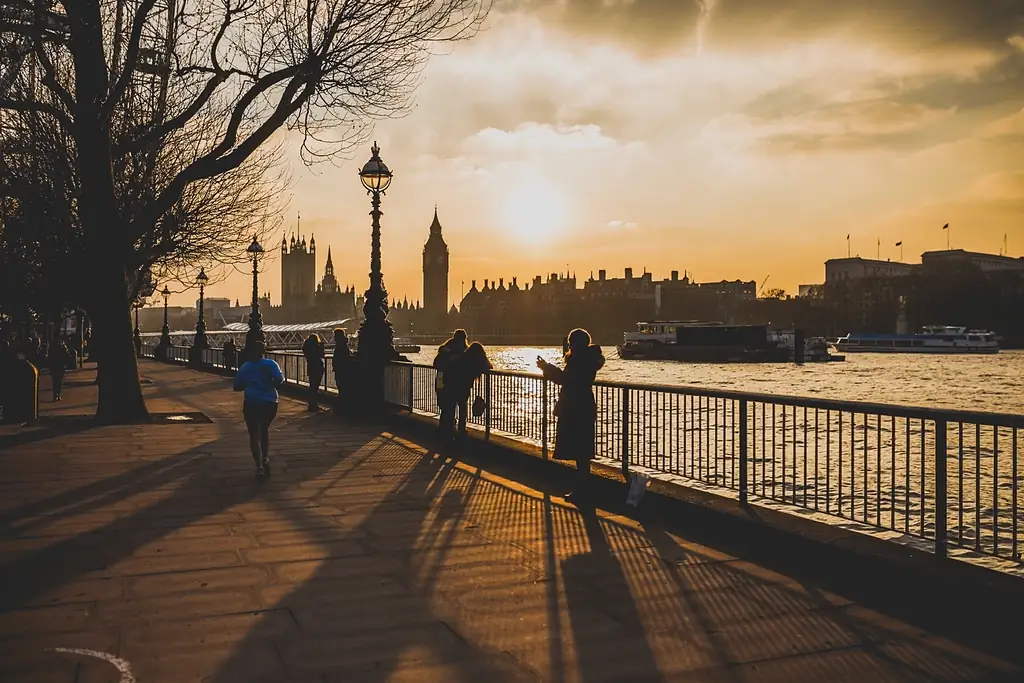 People walking along the Thames at sunset